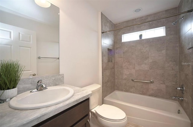 full bathroom with tiled shower / bath combo, toilet, and vanity