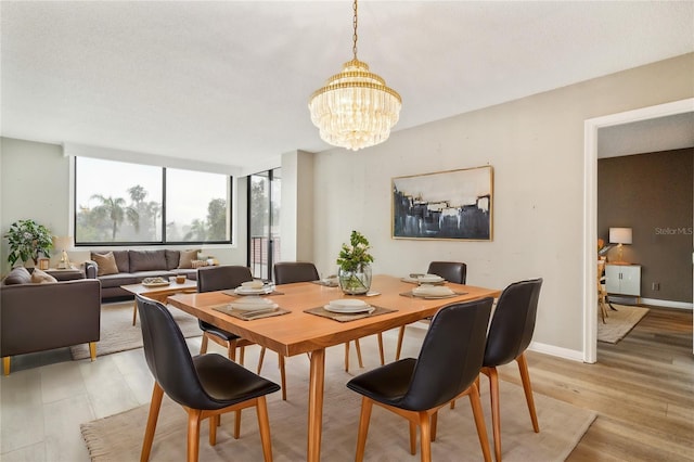 dining area featuring light wood-type flooring and an inviting chandelier