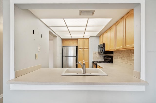 kitchen with sink, light brown cabinets, tasteful backsplash, kitchen peninsula, and black appliances