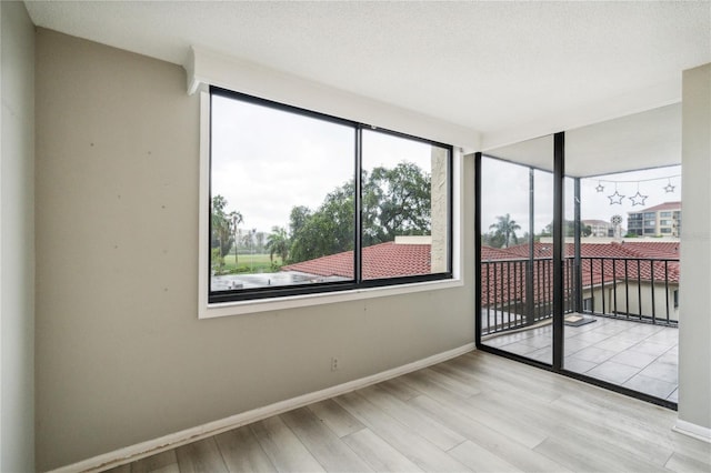 empty room featuring a textured ceiling and light wood-type flooring