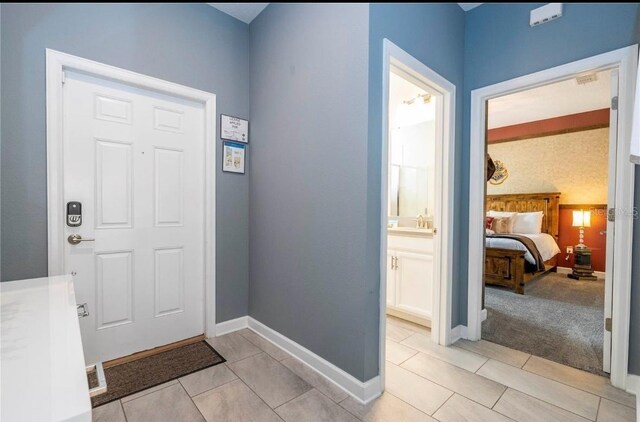 foyer entrance featuring sink and light tile patterned floors