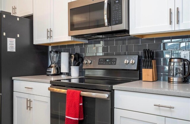 kitchen featuring white cabinetry, backsplash, and stainless steel appliances