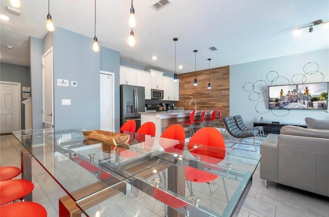 interior space with white cabinetry, appliances with stainless steel finishes, a kitchen island, and pendant lighting