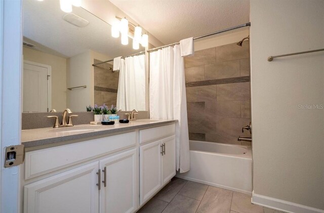 bathroom featuring dual vanity, tile patterned floors, a textured ceiling, and shower / bathtub combination with curtain