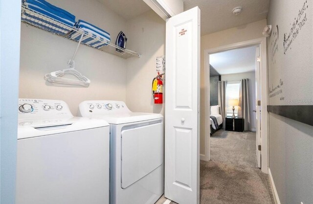 laundry area with light colored carpet and washing machine and dryer