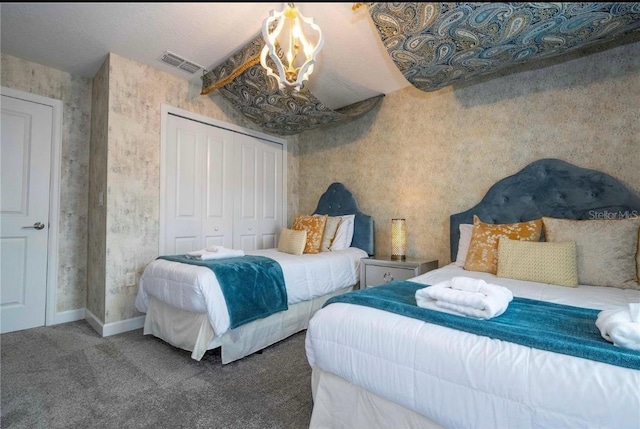 carpeted bedroom with a closet and a chandelier