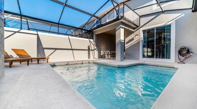 view of swimming pool with a patio area and glass enclosure