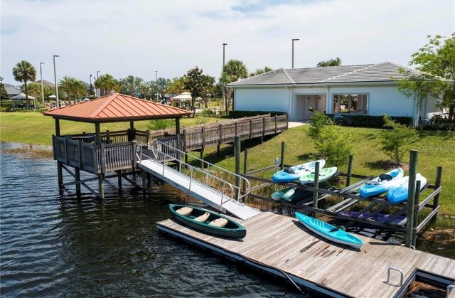 view of dock with a yard and a water view