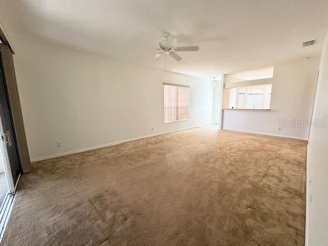 interior space featuring ceiling fan and light carpet