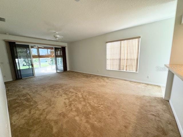 carpeted empty room featuring a textured ceiling