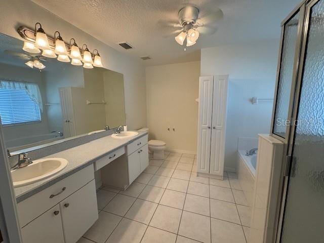 bathroom with a tub, toilet, tile patterned flooring, double vanity, and ceiling fan