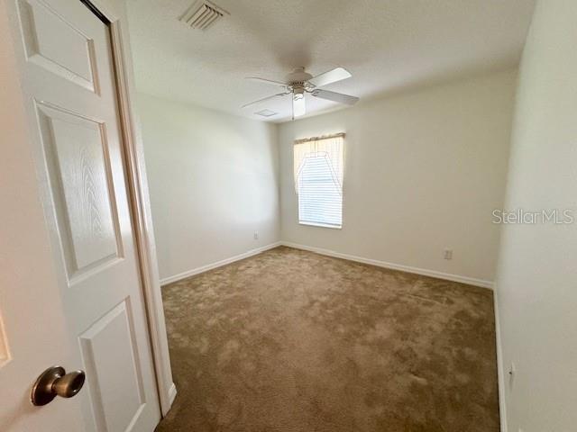 carpeted empty room featuring ceiling fan