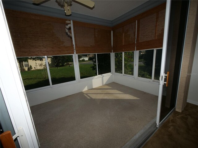 unfurnished sunroom with ceiling fan