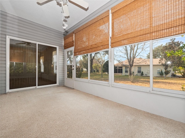 unfurnished sunroom with ceiling fan