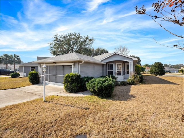 single story home with an attached garage, concrete driveway, and a front yard