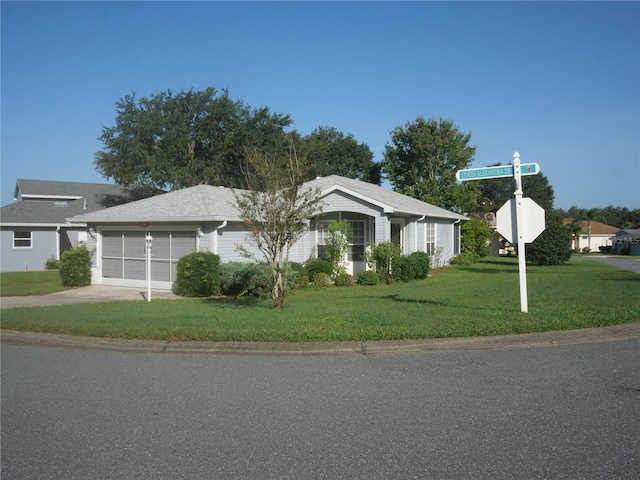 ranch-style home with a garage, driveway, and a front lawn