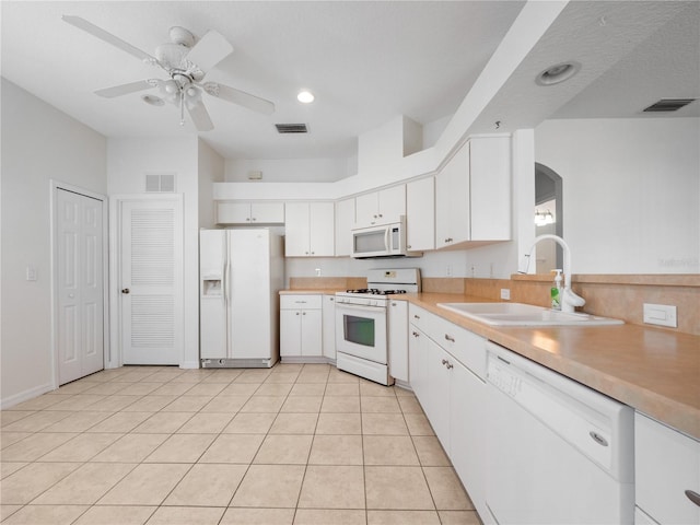 kitchen with white appliances, visible vents, and a sink