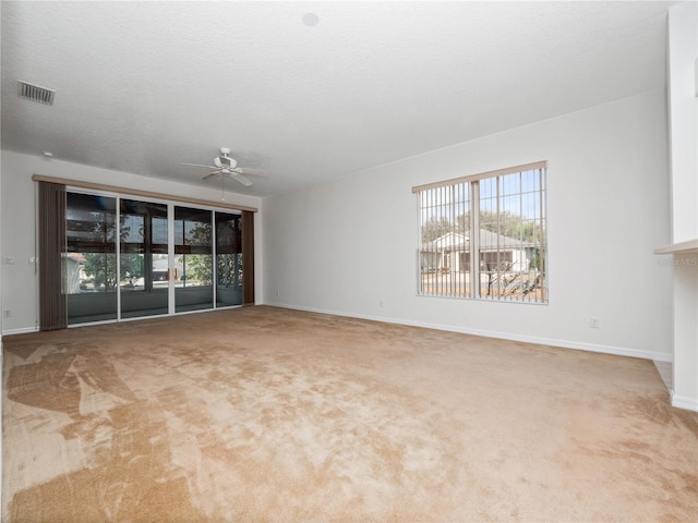 unfurnished living room featuring a ceiling fan, carpet flooring, a textured ceiling, and baseboards