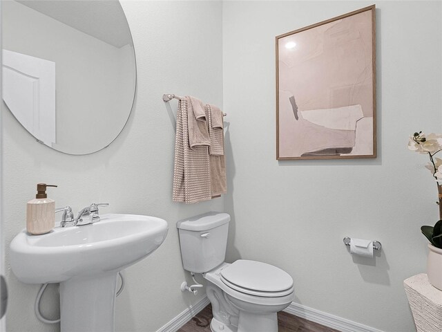 bathroom with hardwood / wood-style flooring and toilet