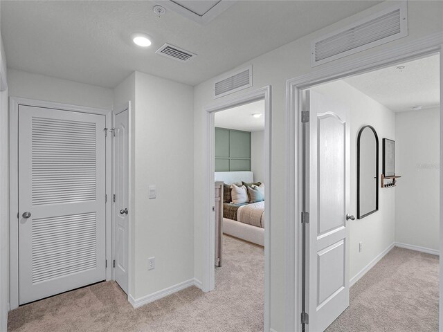 hallway with light colored carpet