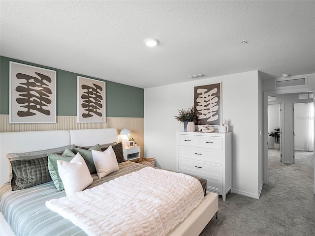 bedroom featuring a textured ceiling and light colored carpet