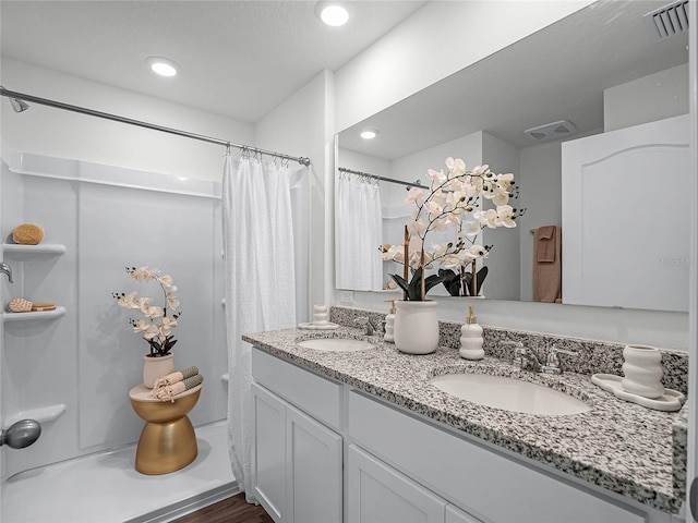 bathroom with hardwood / wood-style flooring and dual bowl vanity