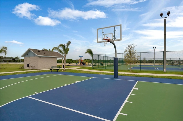 view of basketball court with a lawn and a playground