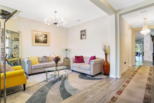 living room with a notable chandelier and light hardwood / wood-style flooring