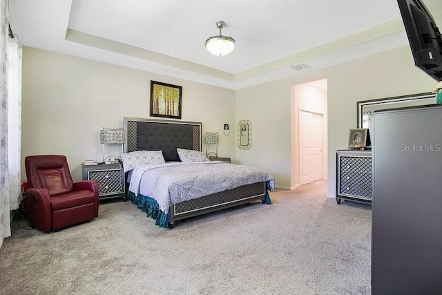 bedroom featuring a raised ceiling and carpet floors