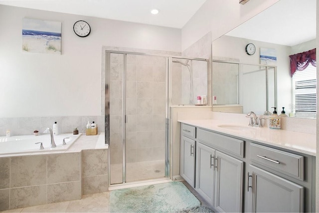 bathroom featuring shower with separate bathtub, vanity, and tile patterned floors