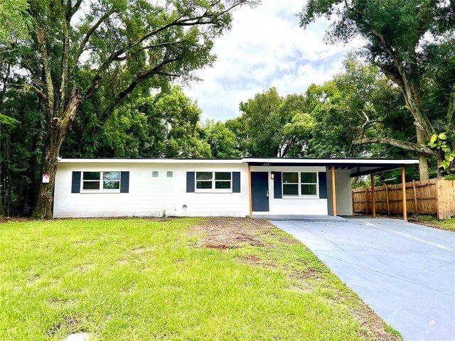 ranch-style house with a carport and a front lawn