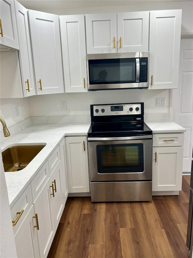 kitchen with dark hardwood / wood-style floors, stainless steel appliances, sink, and white cabinets