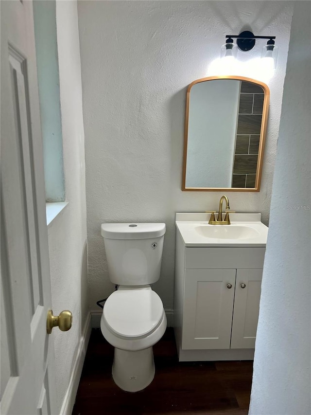 bathroom with vanity, hardwood / wood-style flooring, and toilet