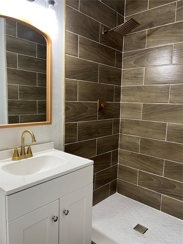 bathroom with vanity and a tile shower