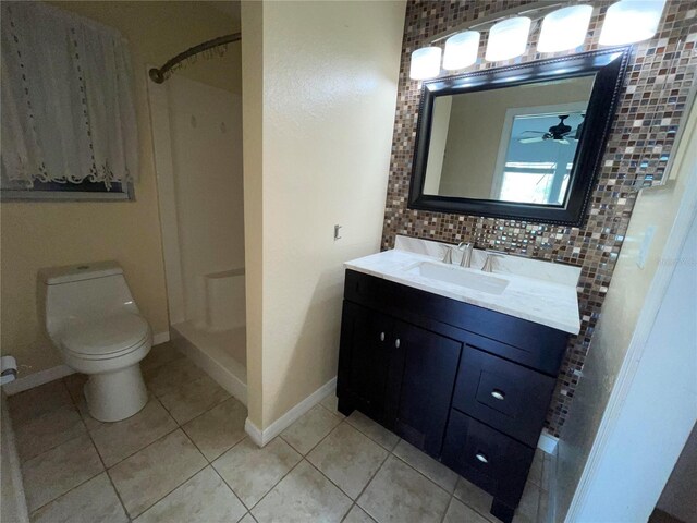 bathroom featuring decorative backsplash, tile patterned floors, toilet, vanity, and ceiling fan