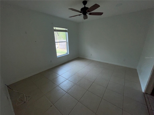 tiled empty room featuring ceiling fan