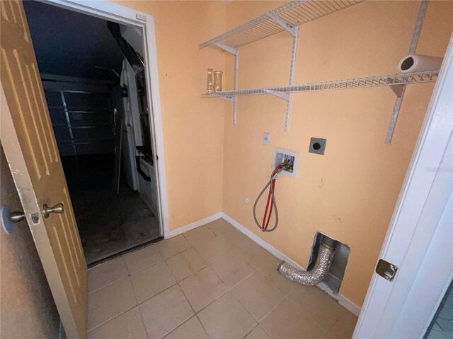 clothes washing area with hookup for an electric dryer, washer hookup, and light tile patterned floors