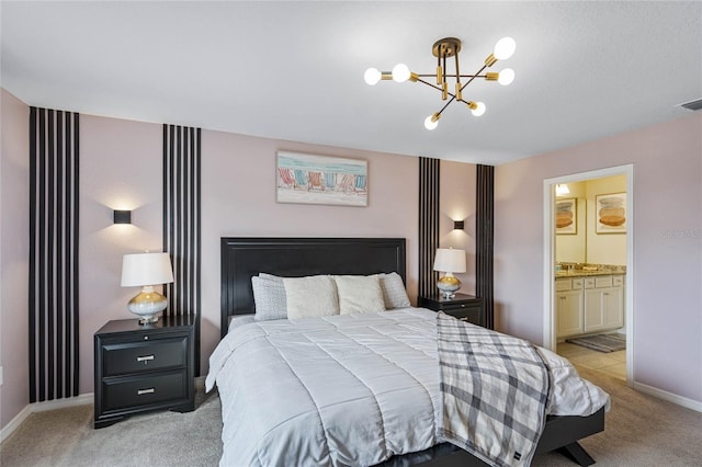 bedroom with sink, a chandelier, light colored carpet, and ensuite bath