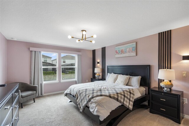 carpeted bedroom with a textured ceiling and a chandelier