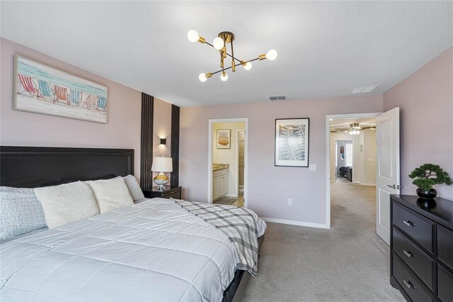 bedroom featuring ensuite bathroom, light carpet, and an inviting chandelier