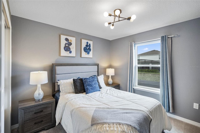 carpeted bedroom featuring a notable chandelier