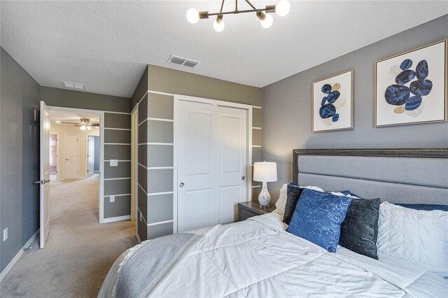 carpeted bedroom featuring an inviting chandelier and a closet