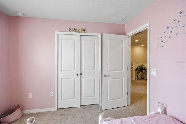 unfurnished bedroom featuring light carpet and a closet