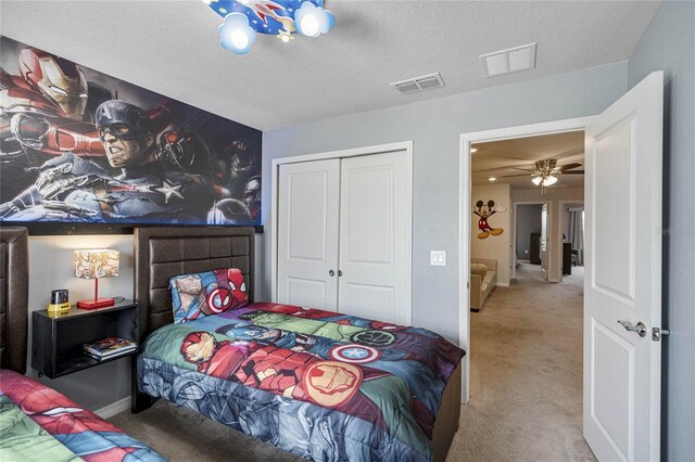 carpeted bedroom featuring a textured ceiling and a closet