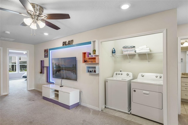 washroom featuring ceiling fan, washing machine and dryer, and light carpet