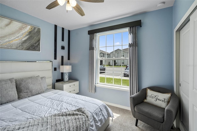 carpeted bedroom with ceiling fan and a closet