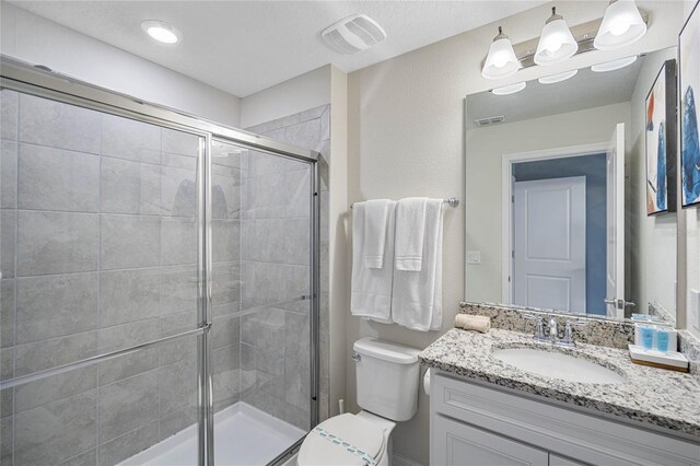 bathroom with toilet, vanity, and walk in shower