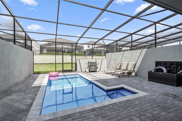 view of pool with glass enclosure and a patio area