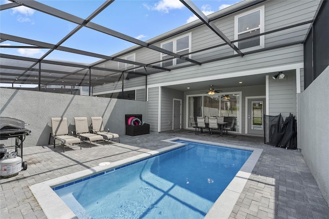 view of swimming pool with ceiling fan, a lanai, and a patio area