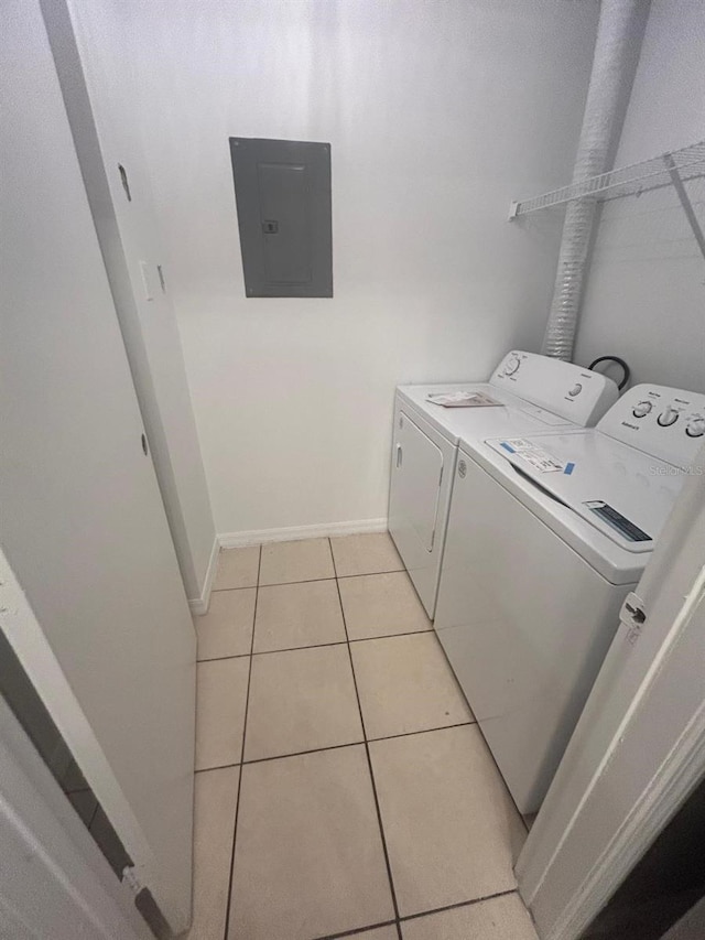 laundry area with light tile patterned flooring, electric panel, and washing machine and dryer